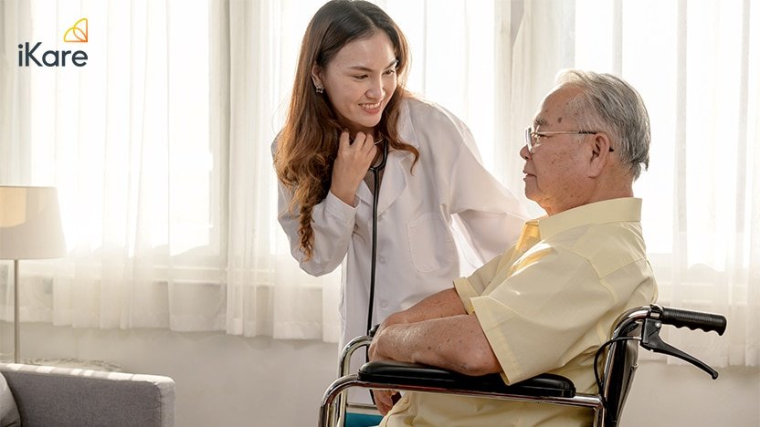 A home healthcare doctor discusses with a senior male patient on wheelchair