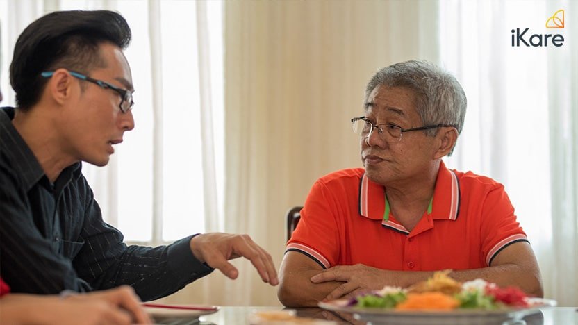 Man sharing food to his father in dinner