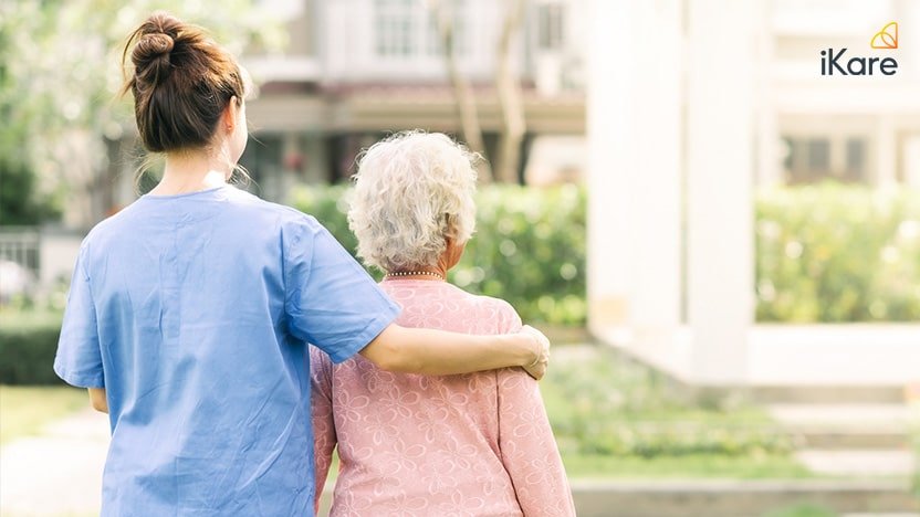 Caregiver Walking With Elderly Woman Outdoor