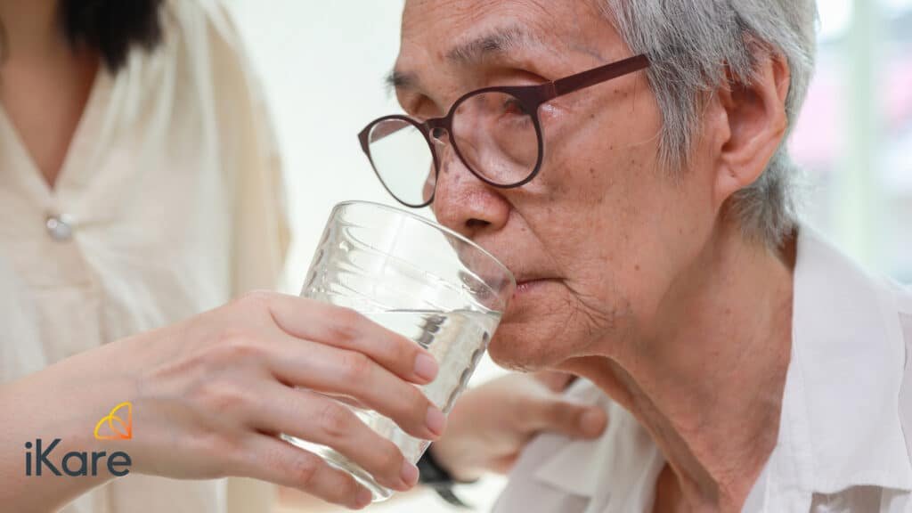 Daughter Feeding Water to Senior