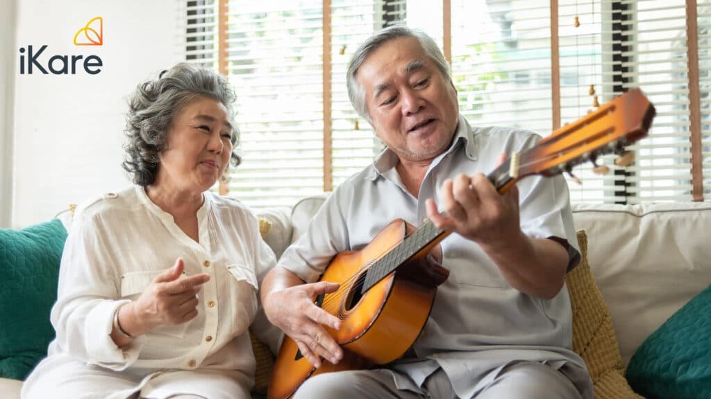 Senior Man Serenading Wife, Playing Guitar at Home